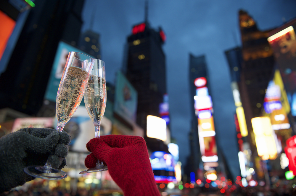 Couple holding champagne glasses in times square